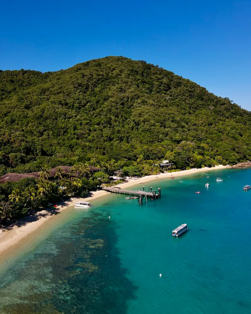 an aerial view of a tropical island with boats