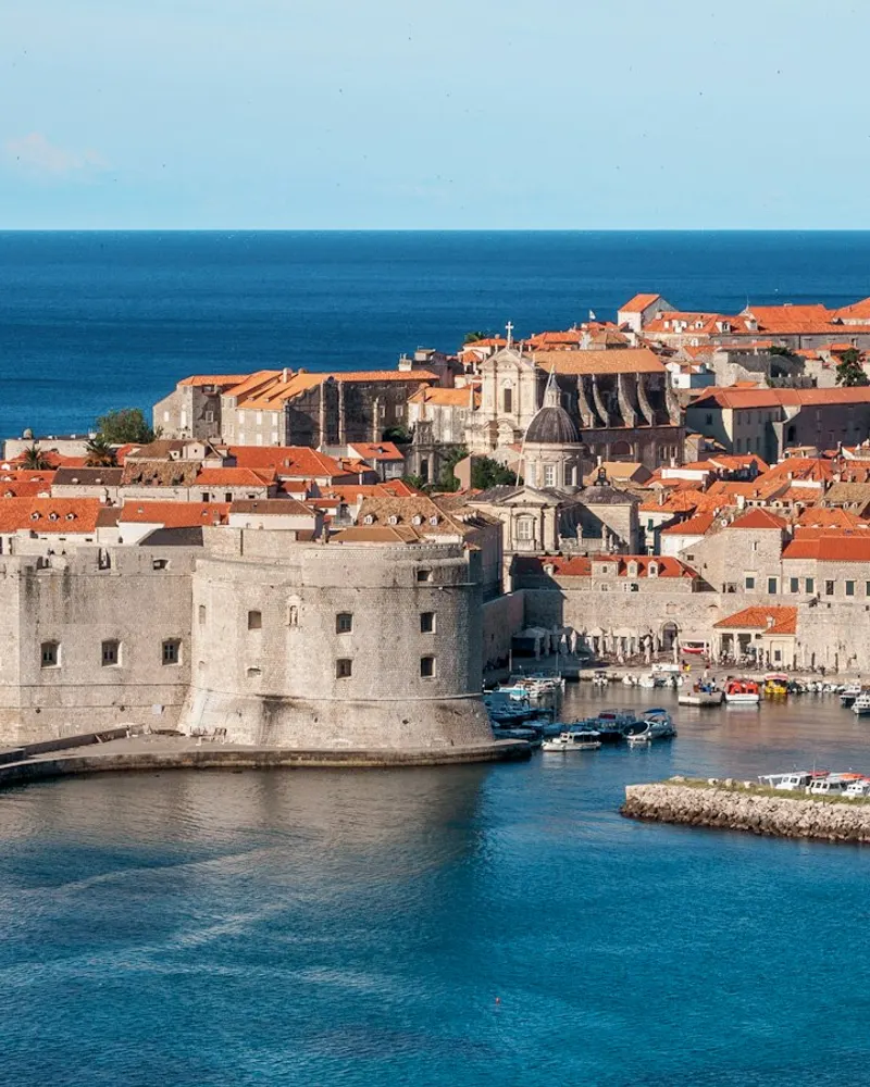 white and red concrete houses beside sea