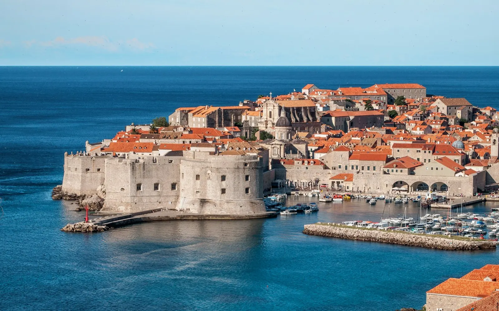 white and red concrete houses beside sea