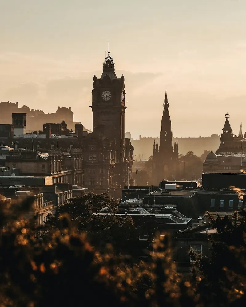 The Balmoral Hotel clock tower and Scott Monument in Edinburgh at golden hour