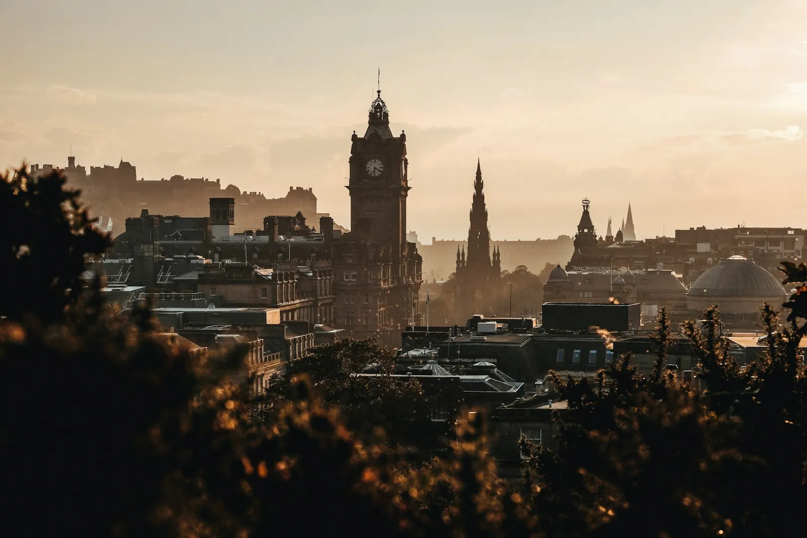 The Balmoral Hotel clock tower and Scott Monument in Edinburgh at golden hour