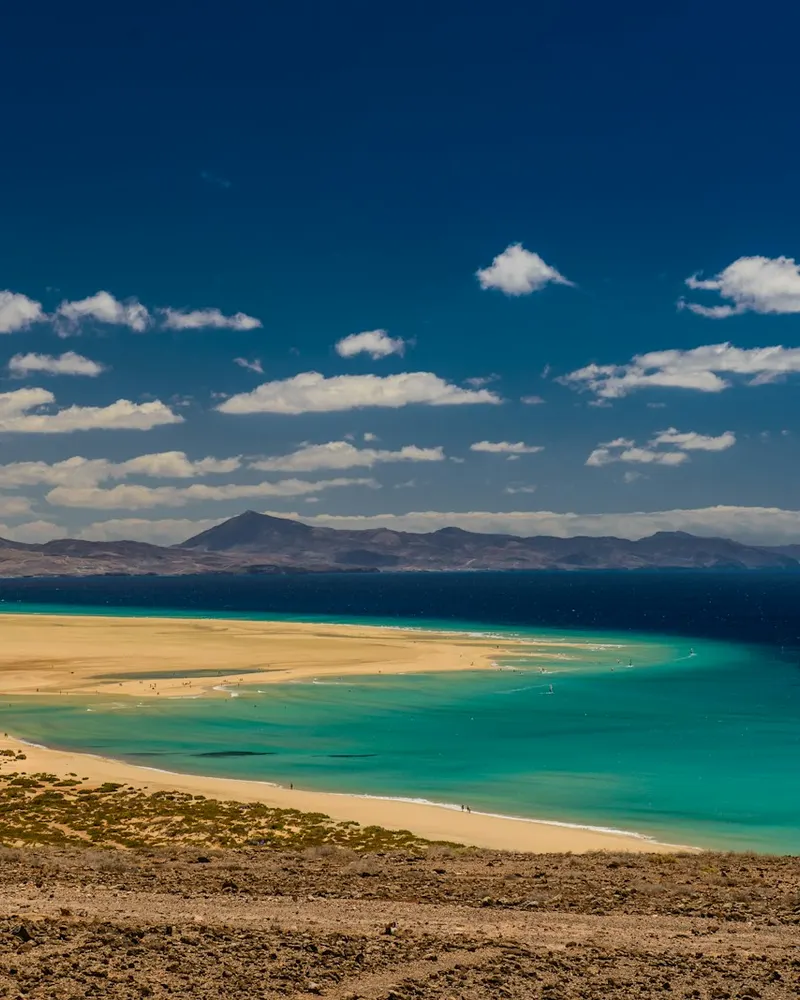 calm body of water under white and blue sky