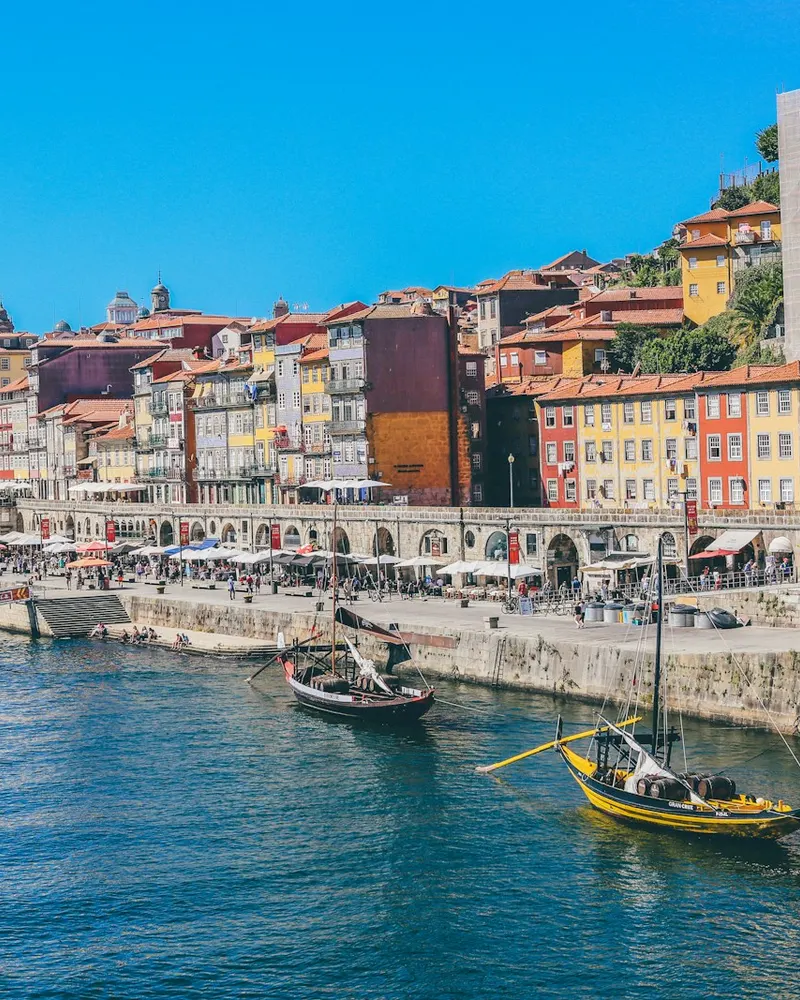 Traditional wooden boats on the Douro River in Porto, Portugal, with colorful buildings