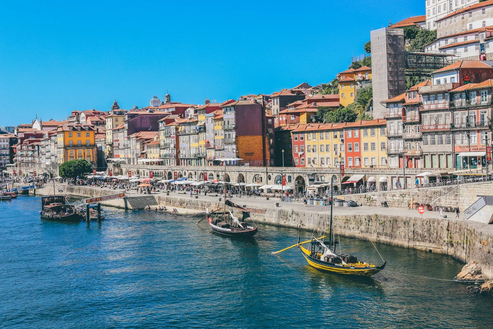 Traditional wooden boats on the Douro River in Porto, Portugal, with colorful buildings