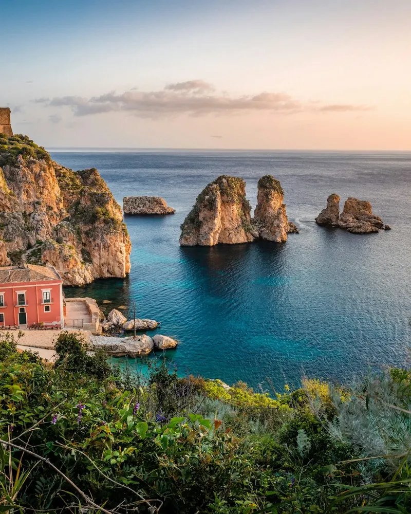 photo of house near cliff and body of water