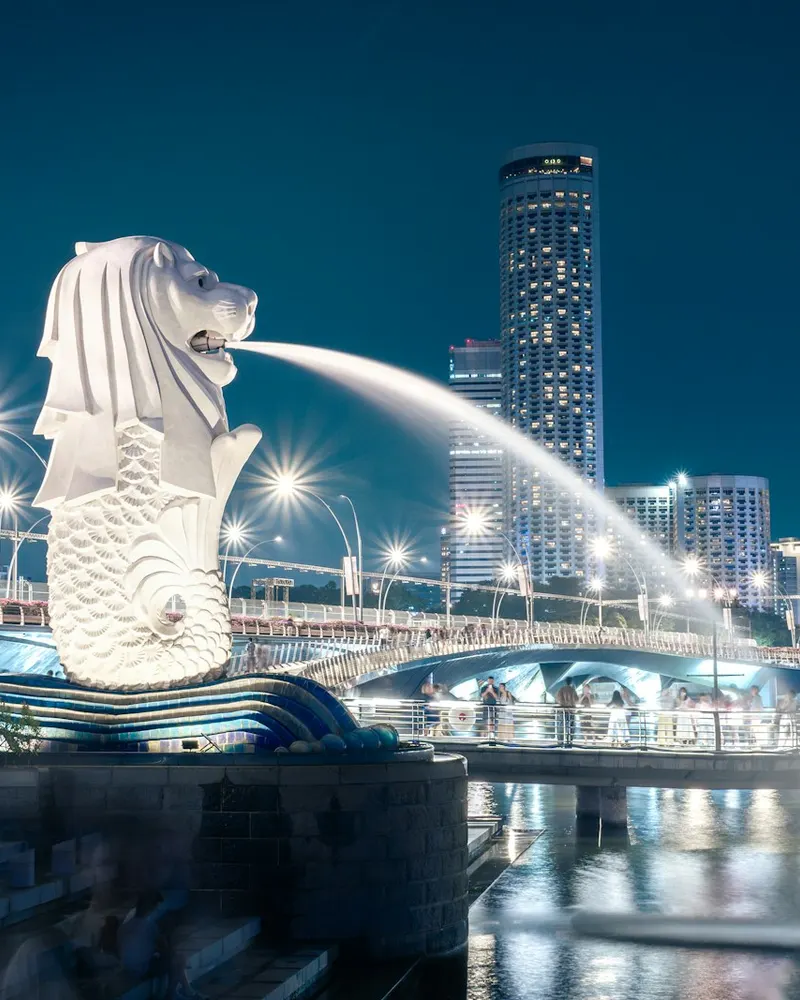 Merlion statue spouting water in singapore at night